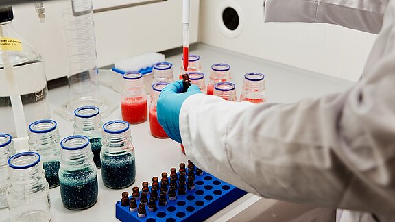 Hand holding a dropper in laboratory