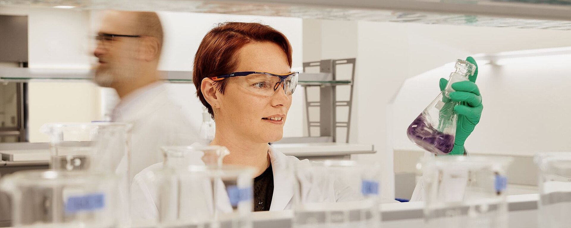 Scientist in a laboratory holding a laboratory flask